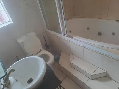 a bathroom with a toilet and a tub and a sink at Matte guest house in Secunda in Secunda