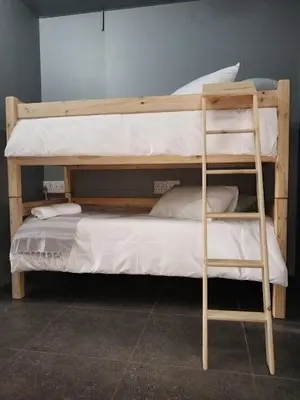 a bunk bed with a ladder next to a bunk bedoublethritisthritisthritisthritis at Kaldi Kothuis in Marble Hall