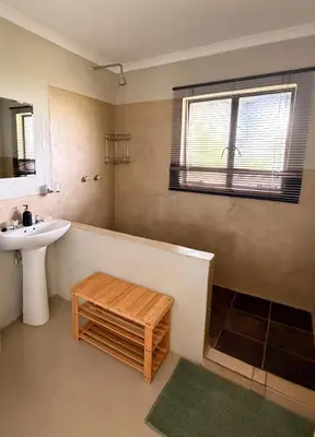 a bathroom with a tub and a sink and a window at Meulensrus in Hoedspruit