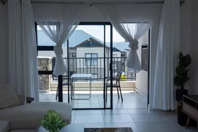 a living room with a couch and a table on a balcony at Feelathome in Midrand
