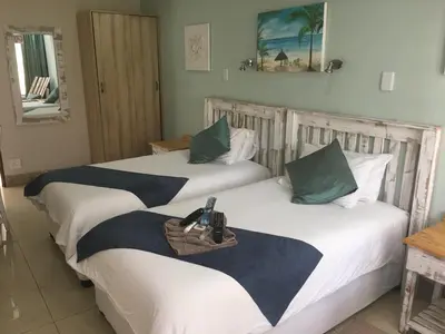 two beds in a hotel room with a phone on the bed at Isle La Breeze Guest House in Witbank