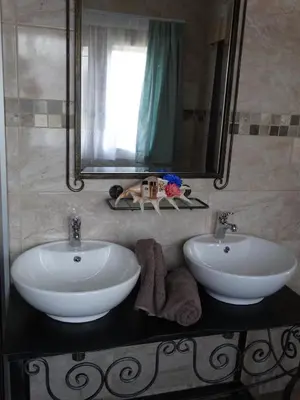 a bathroom with two white sinks and a mirror at Isle La Breeze Guest House in Witbank