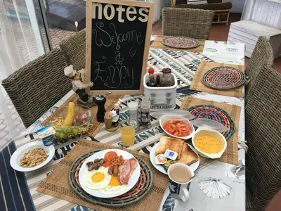 a table topped with breakfast food and a chalk board at Isle La Breeze Guest House in Witbank