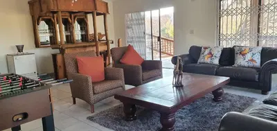a living room with couches and a table and a chessboard at Kulanka Lodge in Roodeplaat