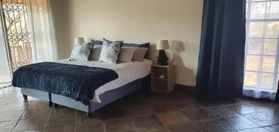 a bedroom with a bed with pillows on it at Kulanka Lodge in Roodeplaat