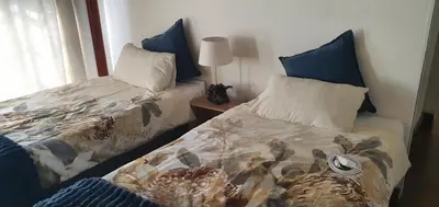two beds sitting next to each other in a bedroom at Kulanka Lodge in Roodeplaat