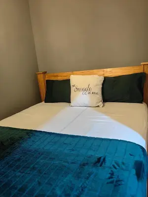 a bed with a pillow on top of it at The Cozy Cabin in Pretoria