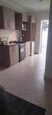 a kitchen with a white tiled floor and appliances at Lerato's Guesthouse in Polokwane