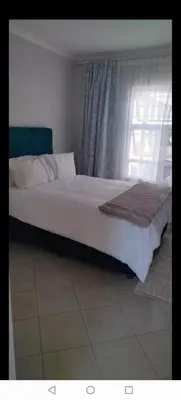 a bed sitting in a bedroom with a window at Lerato's Guesthouse in Polokwane