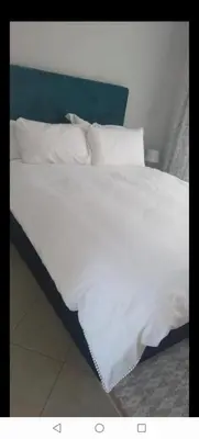 a white bed with white sheets and pillows at Lerato's Guesthouse in Polokwane