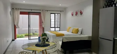 a bedroom with a bed and a glass table at Secured Studio Apartment in Sandton
