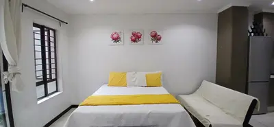 a bedroom with a bed and two paintings on the wall at Secured Studio Apartment in Sandton