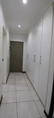 a hallway with white cabinets and a green door at Secured Studio Apartment in Sandton
