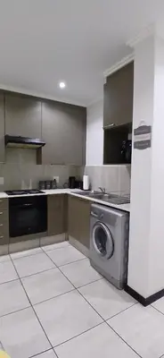 a kitchen with a washer and a washing machine at Secured Studio Apartment in Sandton