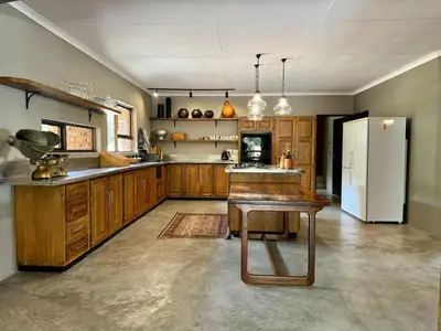 a large kitchen with wooden cabinets and a refrigerator at Ukujabula in Groblersdal