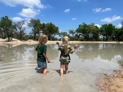two little girls standing in the water on the beach at Ukujabula in Groblersdal