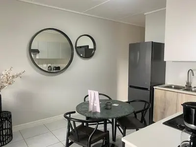 a kitchen with a table with chairs and a mirror at Big deana home in Pretoria