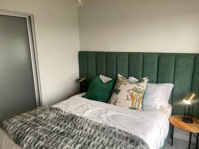 a bed with a green headboard in a bedroom at Big deana home in Pretoria