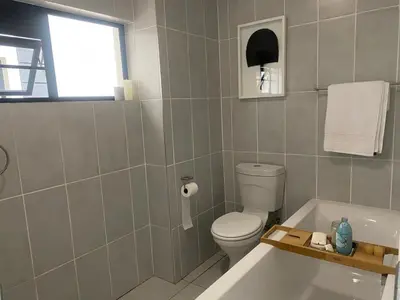 a bathroom with a toilet and a bath tub at Big deana home in Pretoria
