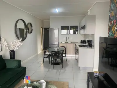 a living room and kitchen with a couch and a table at Big deana home in Pretoria