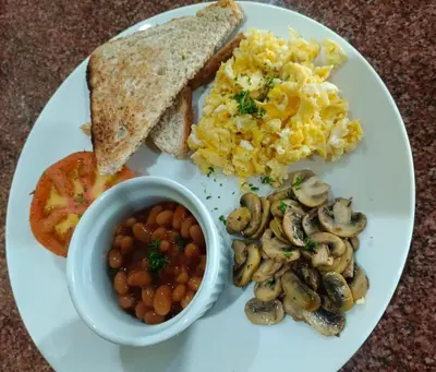a plate of breakfast food with eggs mushrooms and toast at Green Haven in Benoni