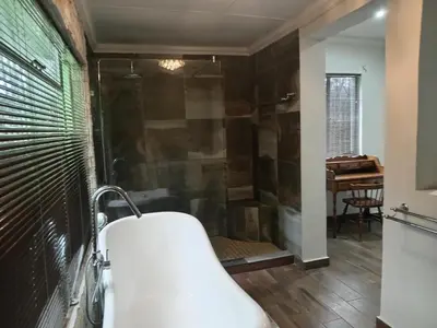 a bathroom with a shower and a bath tub at Green Haven in Benoni