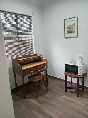a piano in a room with a chair and a microwave at Green Haven in Benoni