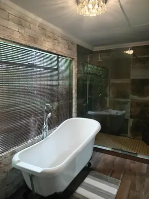 a bathroom with a tub and a sink and a bath tub at Green Haven in Benoni
