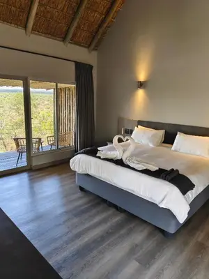 a bedroom with a large bed with a swan on it at Sitrah Private Lodge, Mabalingwe in Mabula