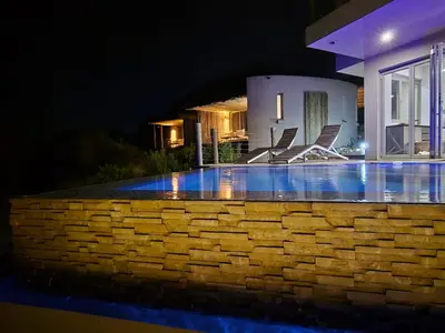 a swimming pool at night in front of a house at Sitrah Private Lodge, Mabalingwe in Mabula