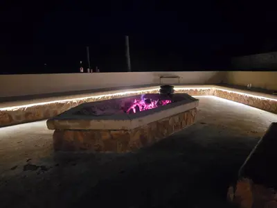 a large stone fountain with pink illumination at night at Sitrah Private Lodge, Mabalingwe in Mabula