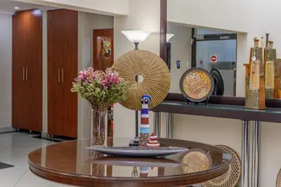 a table with a fan and a vase of flowers on it at Moyres Guest House in Witbank