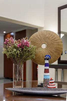a vase of flowers and a statue of a lighthouse on a table at Moyres Guest House in Witbank
