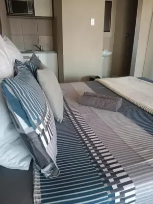 two beds with pillows on them in a bedroom at Rasesa Guesthouse in Soshanguve