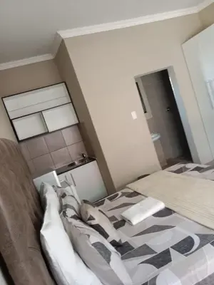 a bedroom with a bed with a checkered floor at Rasesa Guesthouse in Soshanguve