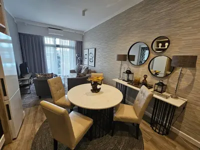 a living room with a table and chairs and a couch at Menlyn Maine Trilogy Collection in Pretoria