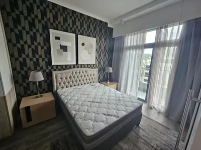 a bedroom with a white bed and a black and white wall at Menlyn Maine Trilogy Collection in Pretoria
