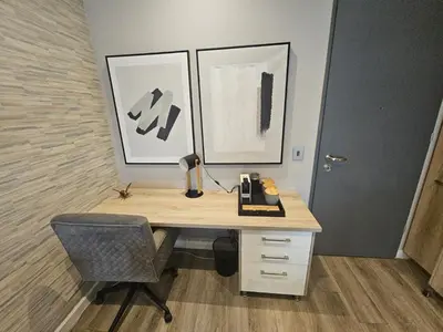 an office with a desk with a chair and two paintings at Menlyn Maine Trilogy Collection in Pretoria