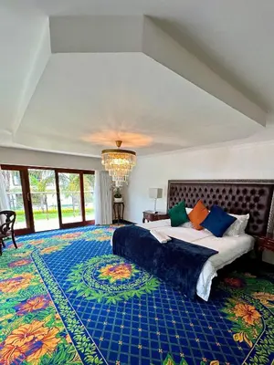 a large bedroom with a large bed and a chandelier at Concordia Boutique Venue in Midrand