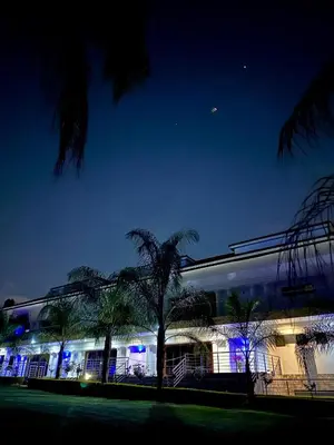 a building with palm trees in front of it at night at Concordia Boutique Venue in Midrand