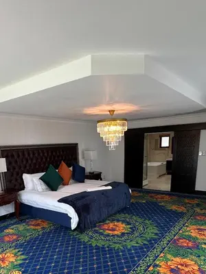 a bedroom with a large bed and a chandelier at Concordia Boutique Venue in Midrand