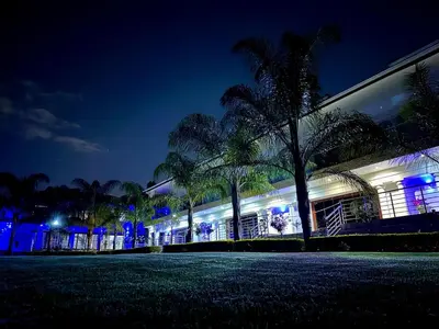 a building with palm trees in front of it at night at Concordia Boutique Venue in Midrand