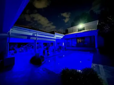 a house with a blue lighted swimming pool at night at Concordia Boutique Venue in Midrand