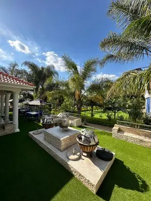 a garden with two large vases on a lawn at Concordia Boutique Venue in Midrand
