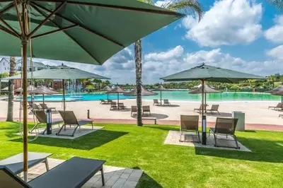 a resort with chairs and umbrellas and a pool at Blyde in Pretoria