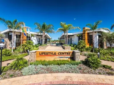 a sign in front of a house with palm trees at Blyde in Pretoria