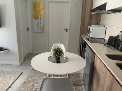 a small kitchen with a white table and chairs at Blyde in Pretoria