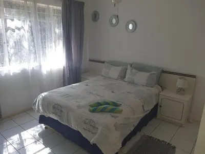 a bedroom with a bed with a green towel on it at Cottage 2 at Cynthias Country in Hartbeespoort