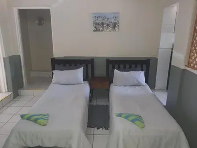 two beds sitting next to each other in a room at Cottage 2 at Cynthias Country in Hartbeespoort