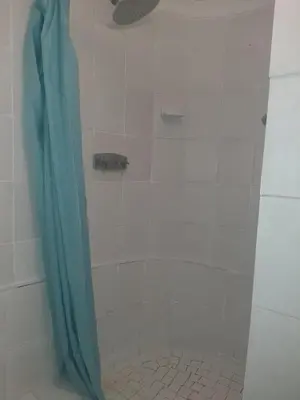 a shower with a blue shower curtain in a bathroom at Cottage 2 at Cynthias Country in Hartbeespoort